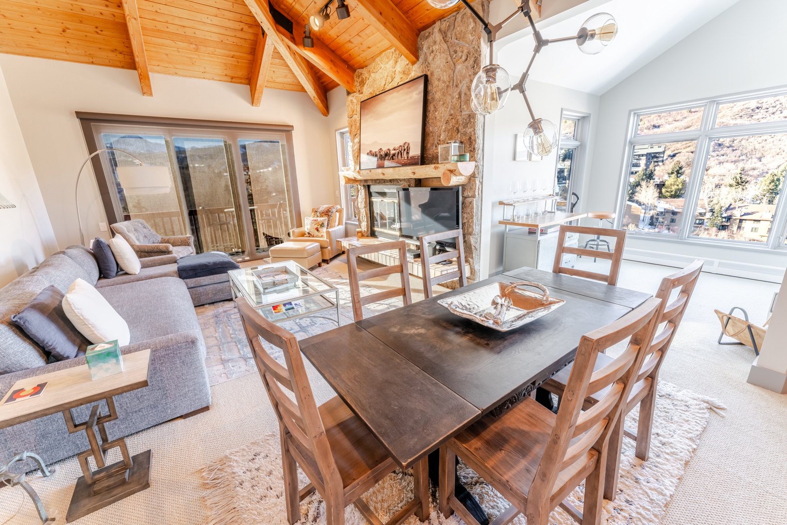 Relax in your bright, open-concept retreat with exposed beams, cozy fireplace, and mountain views through oversized windows.