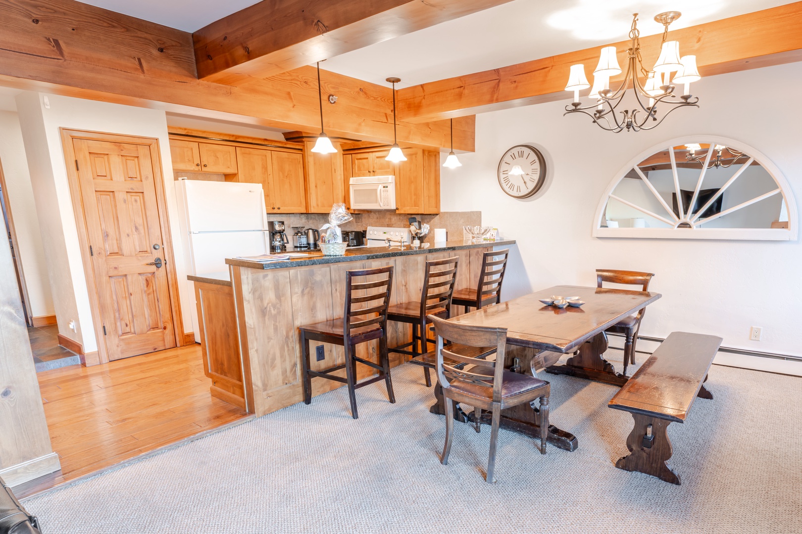 Gather around your spacious dining table and kitchen island, where rustic wood beams and warm lighting create the perfect atmosphere for memorable meals together.