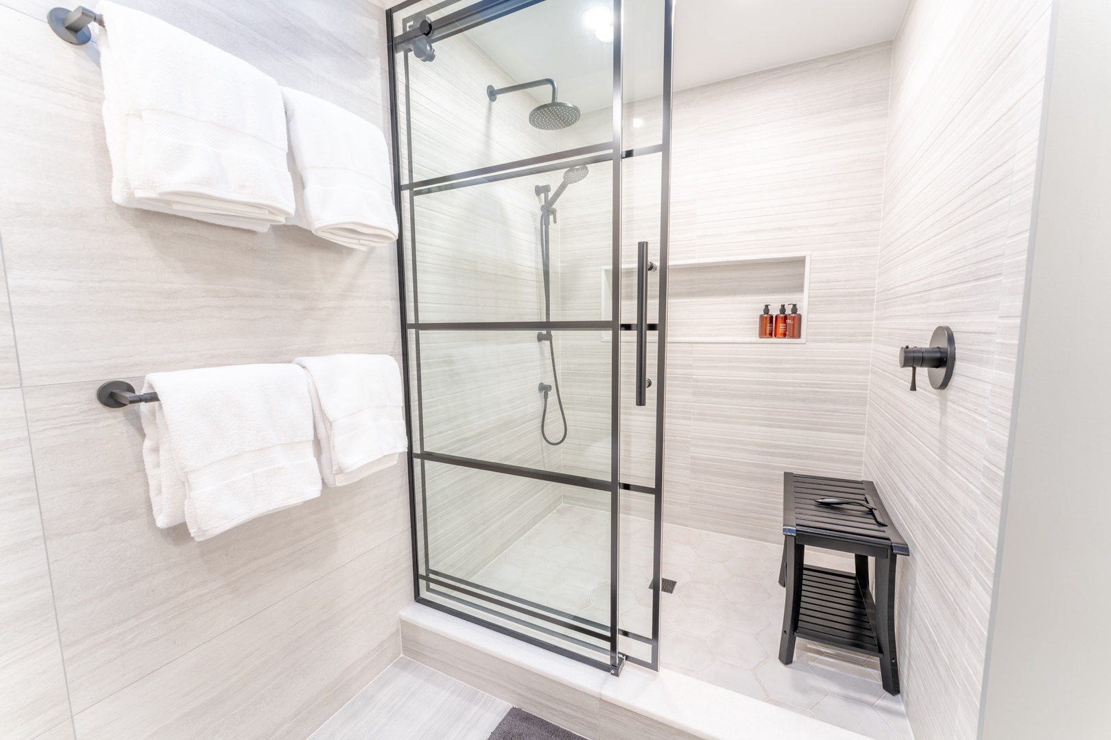 Step into your spa-like shower with rainfall head and built-in bench - fresh towels await your relaxing retreat.
