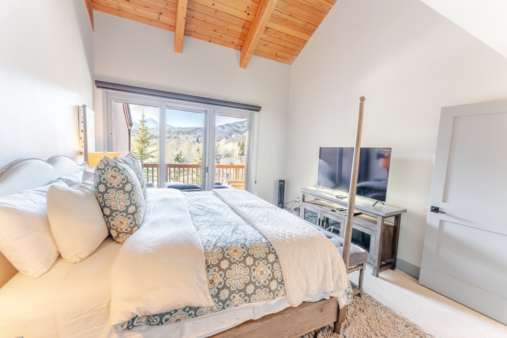 Wake up to stunning mountain views from your cozy bedroom, where exposed wood beams and modern comfort create the perfect alpine retreat.