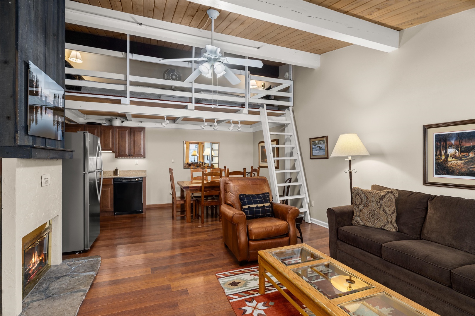 Cozy loft living awaits with soaring wood beam ceilings, crackling fireplace, and open-concept design perfect for your mountain getaway.