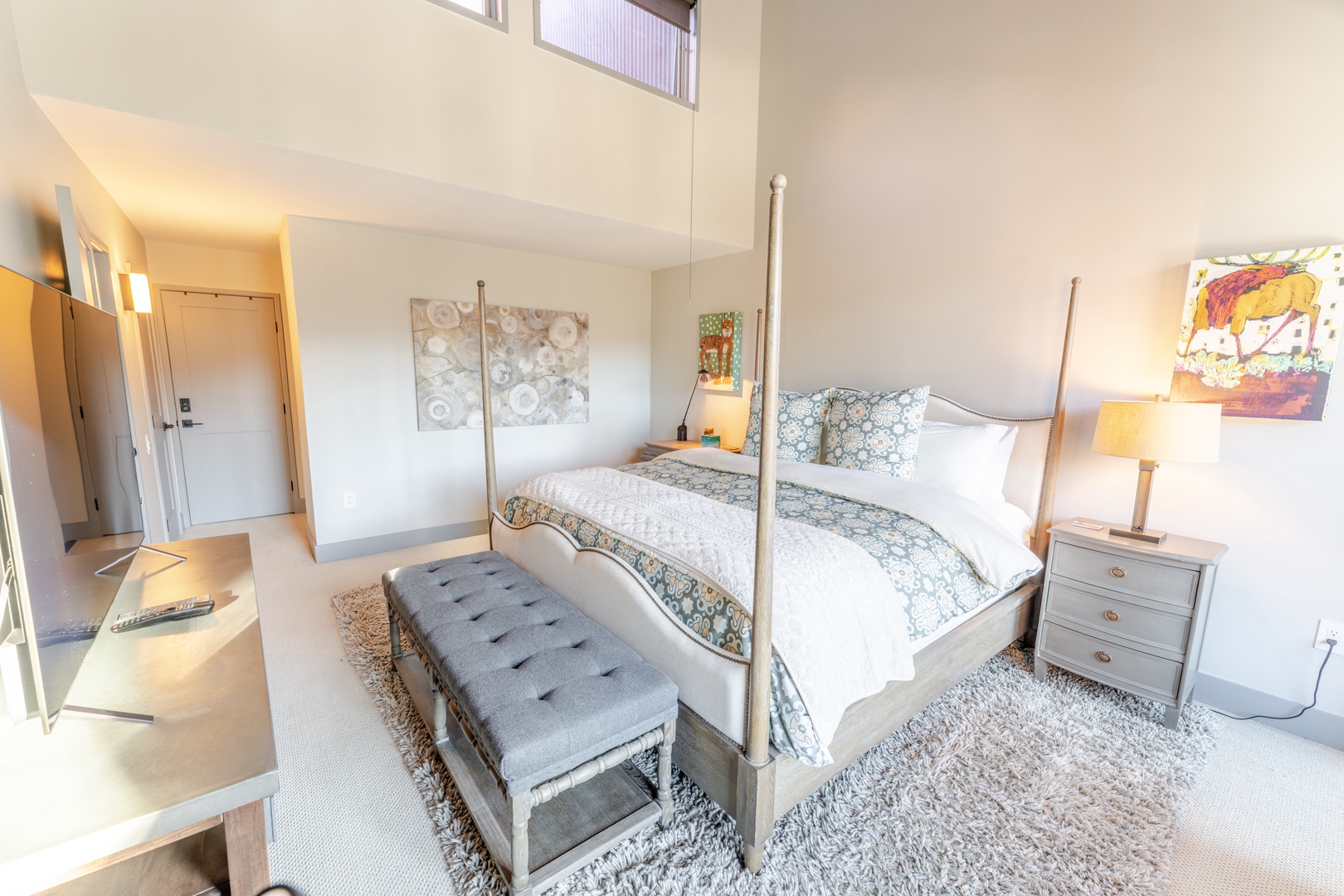 Sink into your elegant four-poster bed surrounded by soft textures and warm lighting in this sophisticated bedroom retreat.
