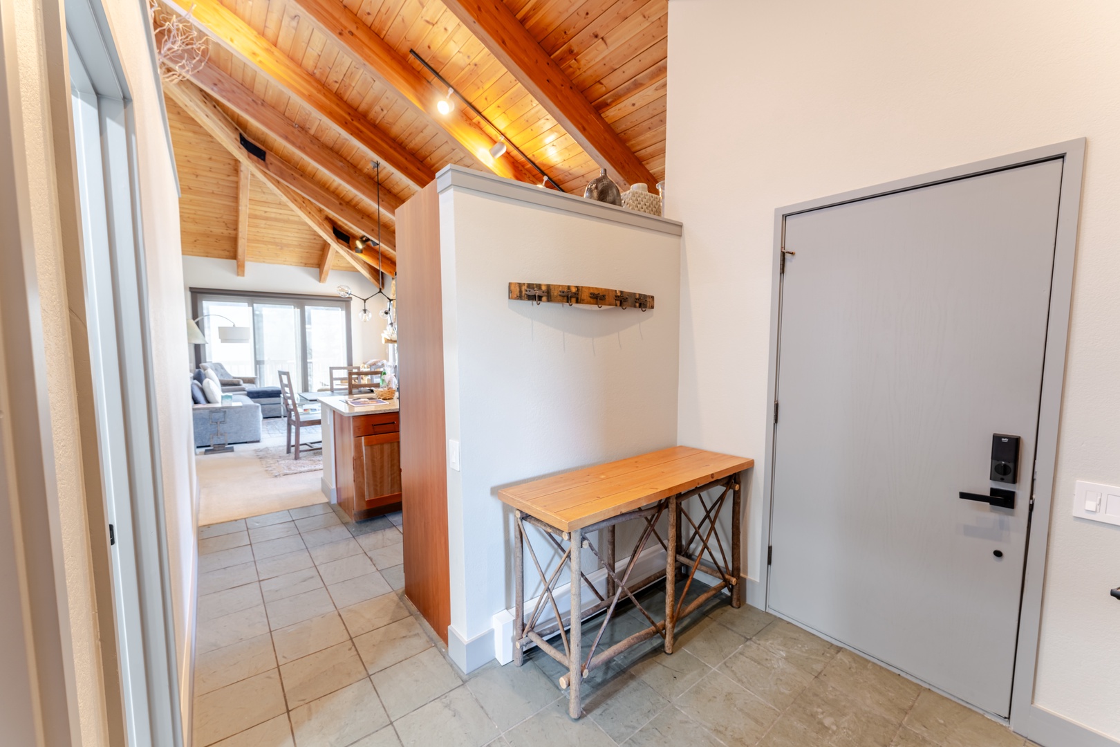 Step into your welcoming entryway with stunning wood beam ceilings and rustic table—your perfect arrival point to home comfort.