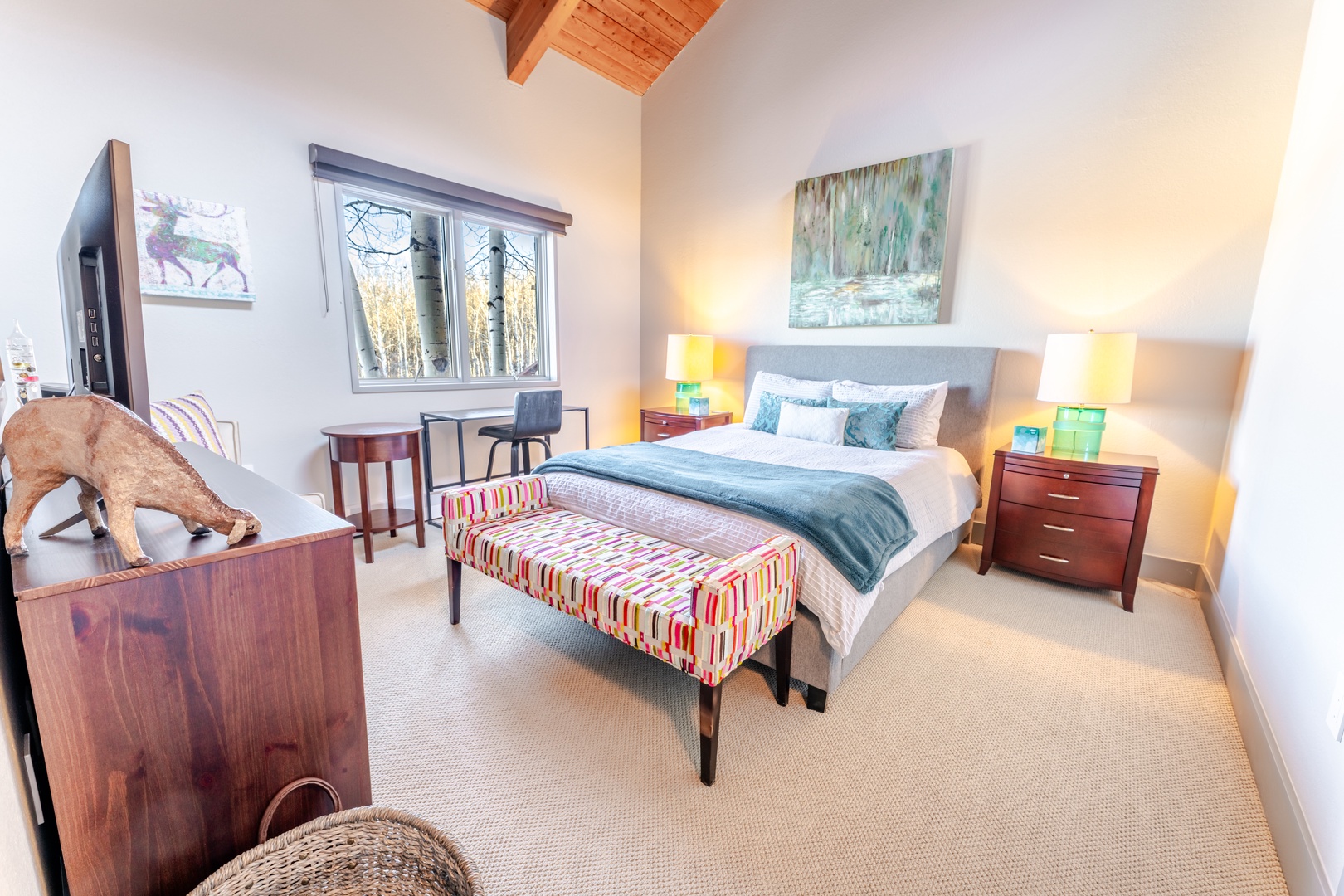 Drift off in this serene guest bedroom where exposed wooden beams meet modern comfort, soft linens await your arrival, and gentle lighting creates the perfect ambiance.