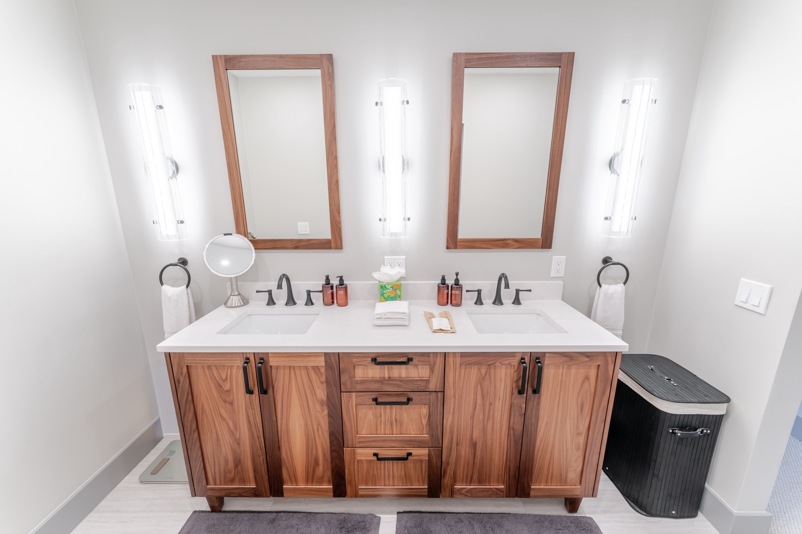 Freshen up in your elegant dual-sink vanity with warm wood finishes and thoughtful amenities perfectly arranged for your comfort.