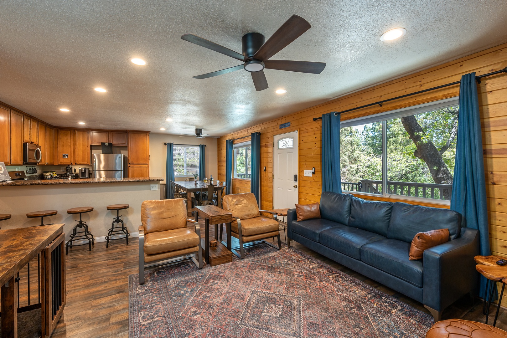 Relax in this inviting open-concept space where warm wood tones and natural light create your perfect home away from home, with comfy seating and views of the surrounding trees.