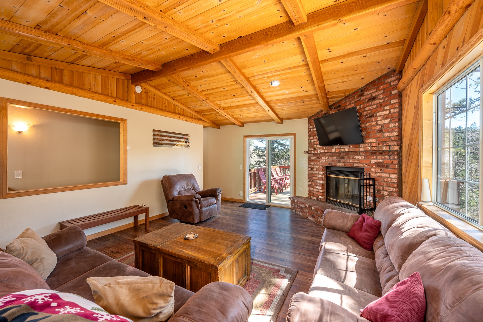 Gather in your cozy living room where exposed wood beams meet rustic brick fireplace, perfect for relaxing evenings.