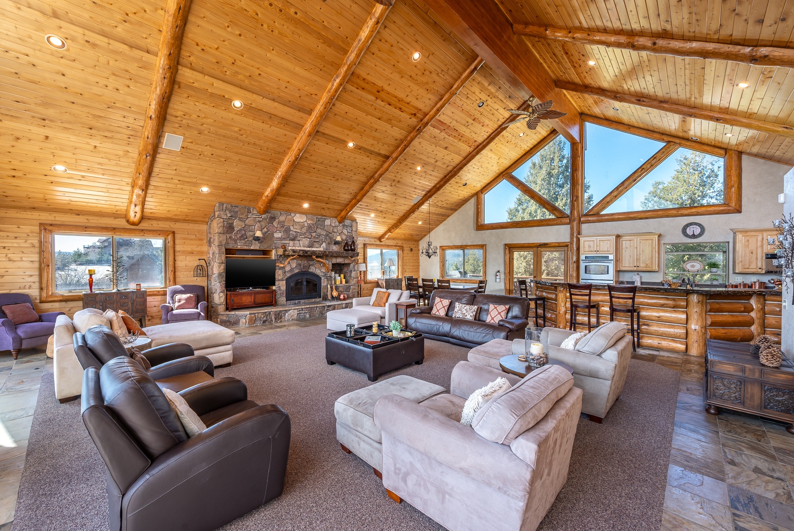 Unwind in this stunning great room where soaring timber ceilings meet cozy comfort. Your group can gather around the stone fireplace or spread out across plush seating.