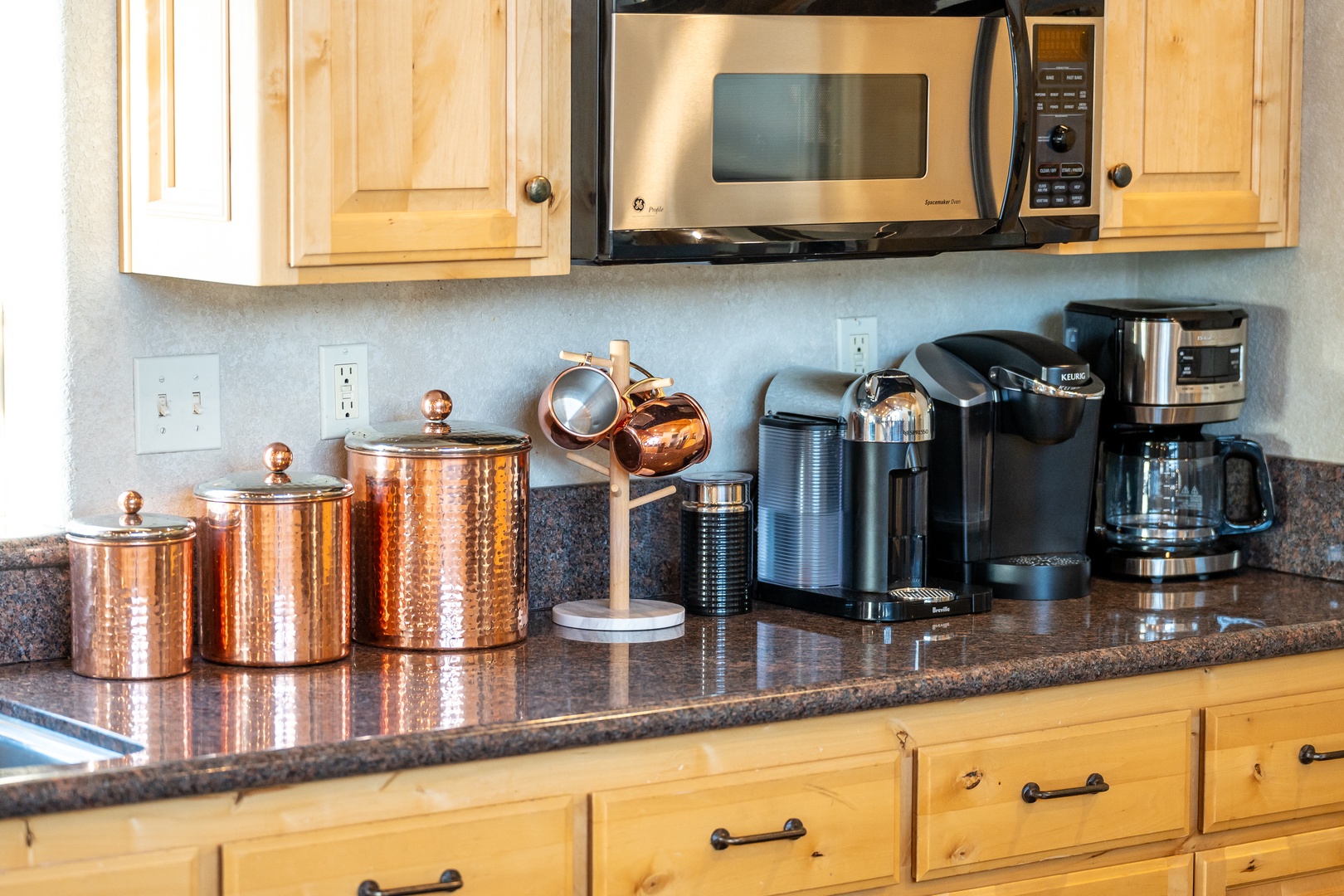 Your fully-equipped kitchen awaits with gleaming copper canisters, premium coffee makers, and everything needed for perfect morning brews and home-cooked meals.