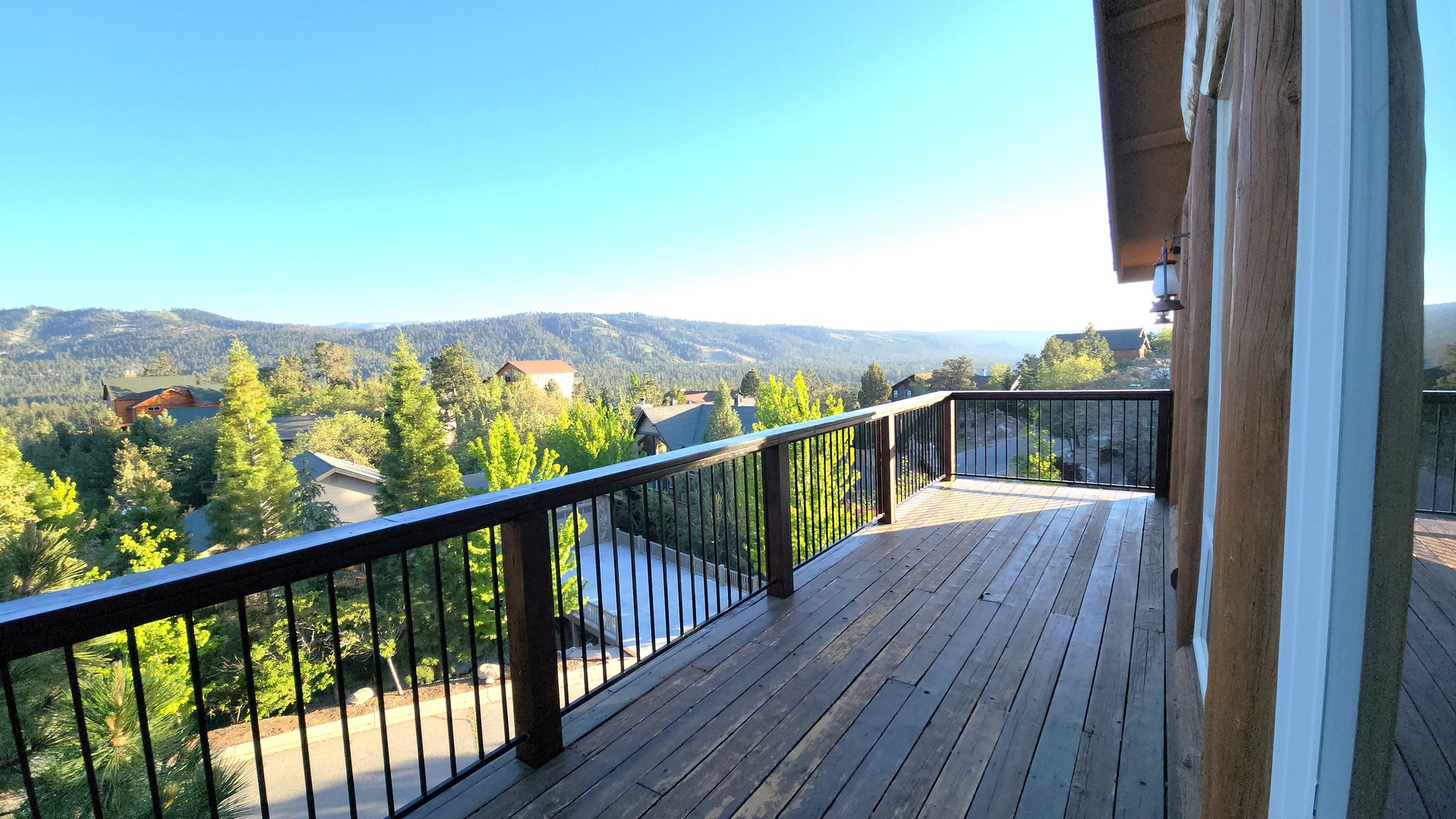 Spacious deck offering sweeping mountain vistas with lush forested valleys below. The surrounding area provides a peaceful mountain retreat setting.