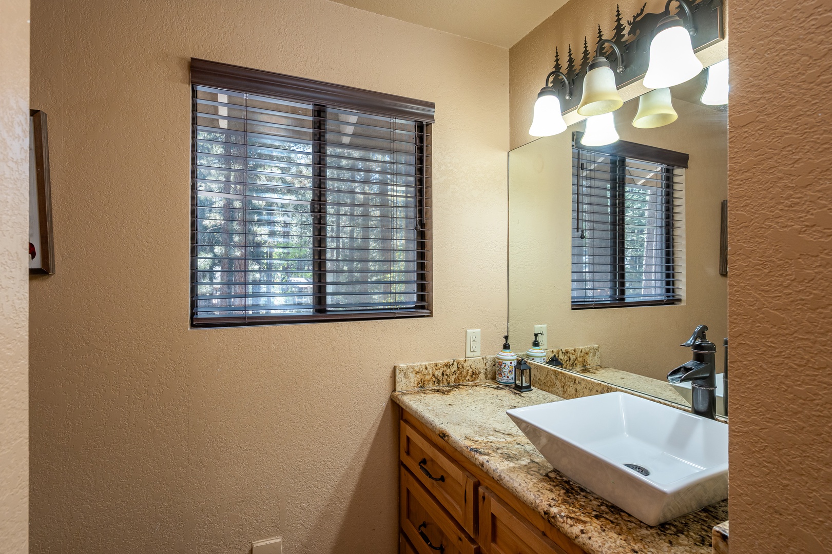 Freshen up in your private bathroom with natural light, stylish granite counters, and rustic charm—perfect for unwinding after a day of adventure.