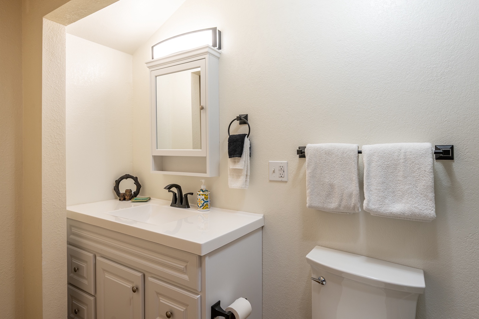 Step into your freshly updated bathroom, where soft lighting and plush white towels await you. The clean vanity and thoughtful details create a relaxing retreat after a day of adventure.