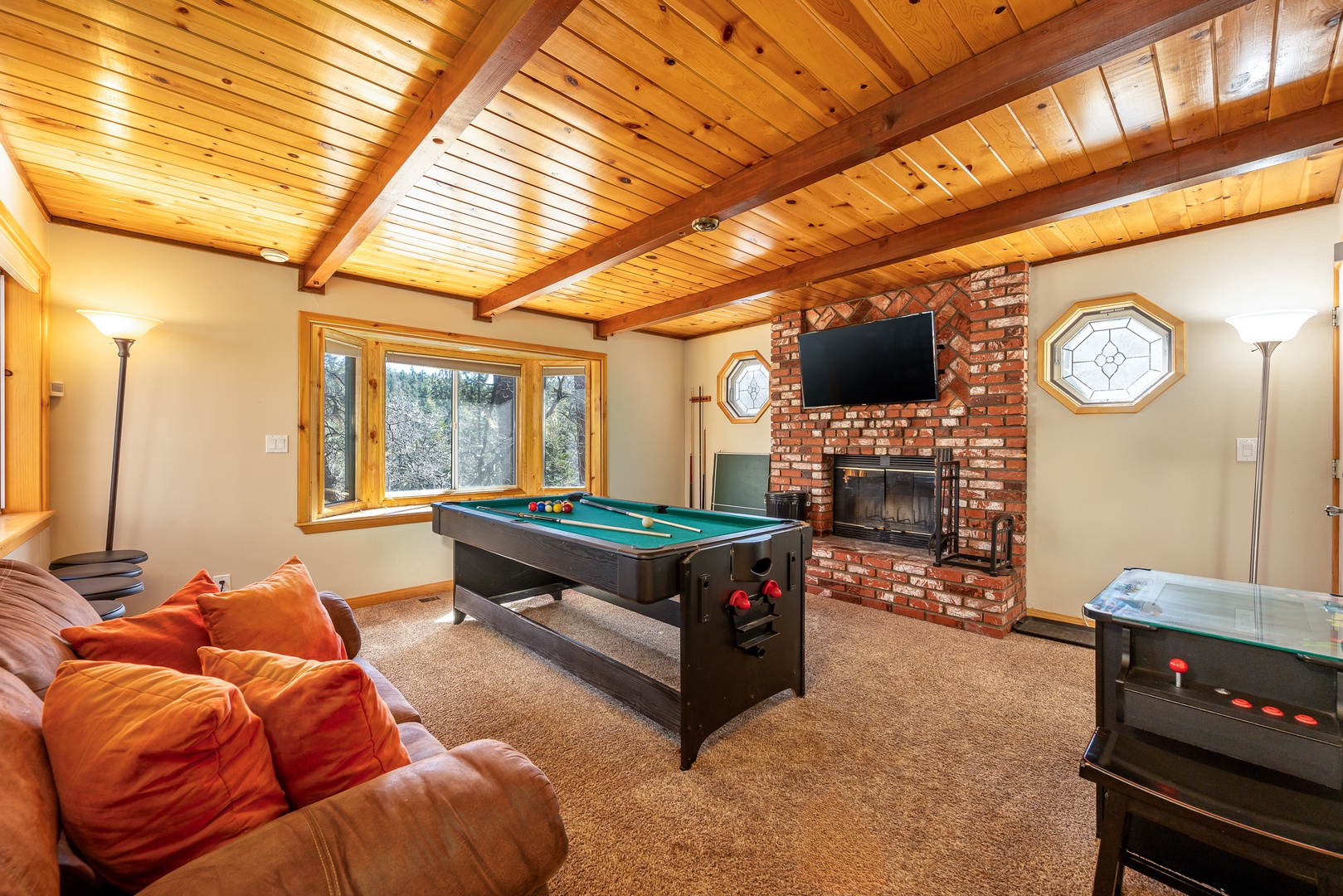 Challenge friends to pool while the fireplace warms your cozy game room retreat with vaulted wood ceilings.