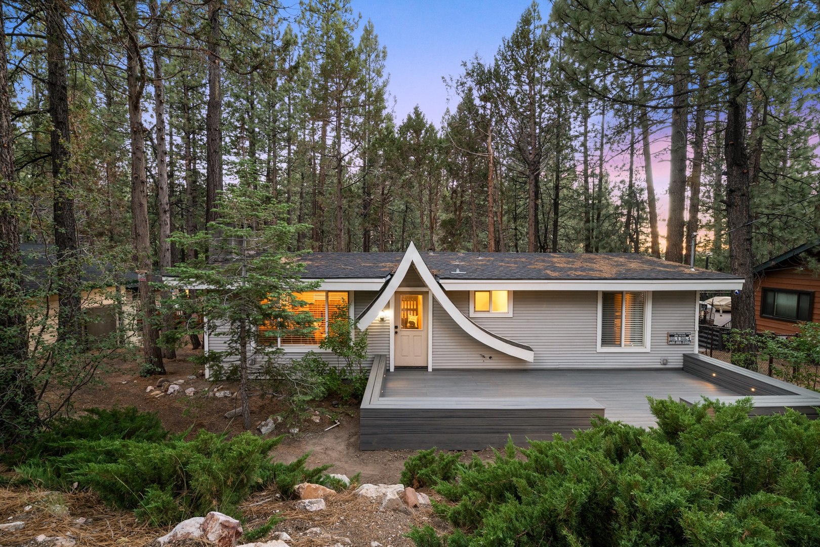 Modern retreat nestled among towering pines  awaits your arrival in this peaceful woodland setting.