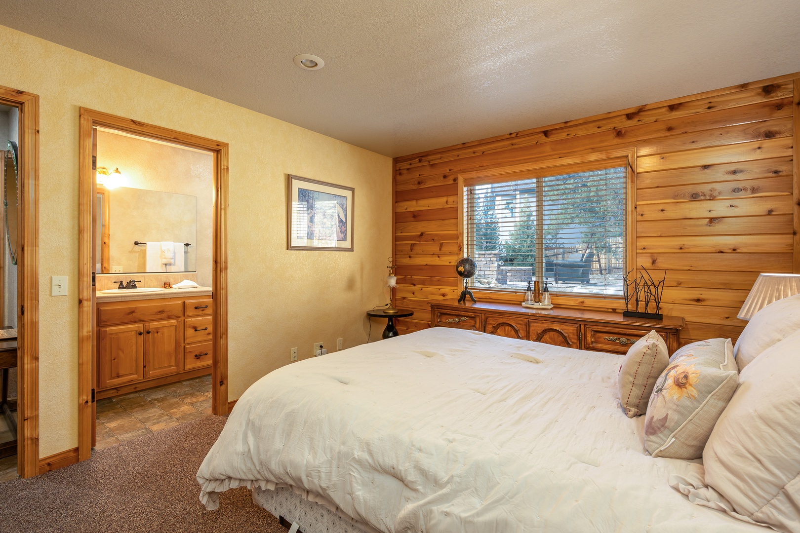 Sink into crisp linens in your rustic retreat, where warm wood accents and peaceful views create the perfect mountain getaway sanctuary.