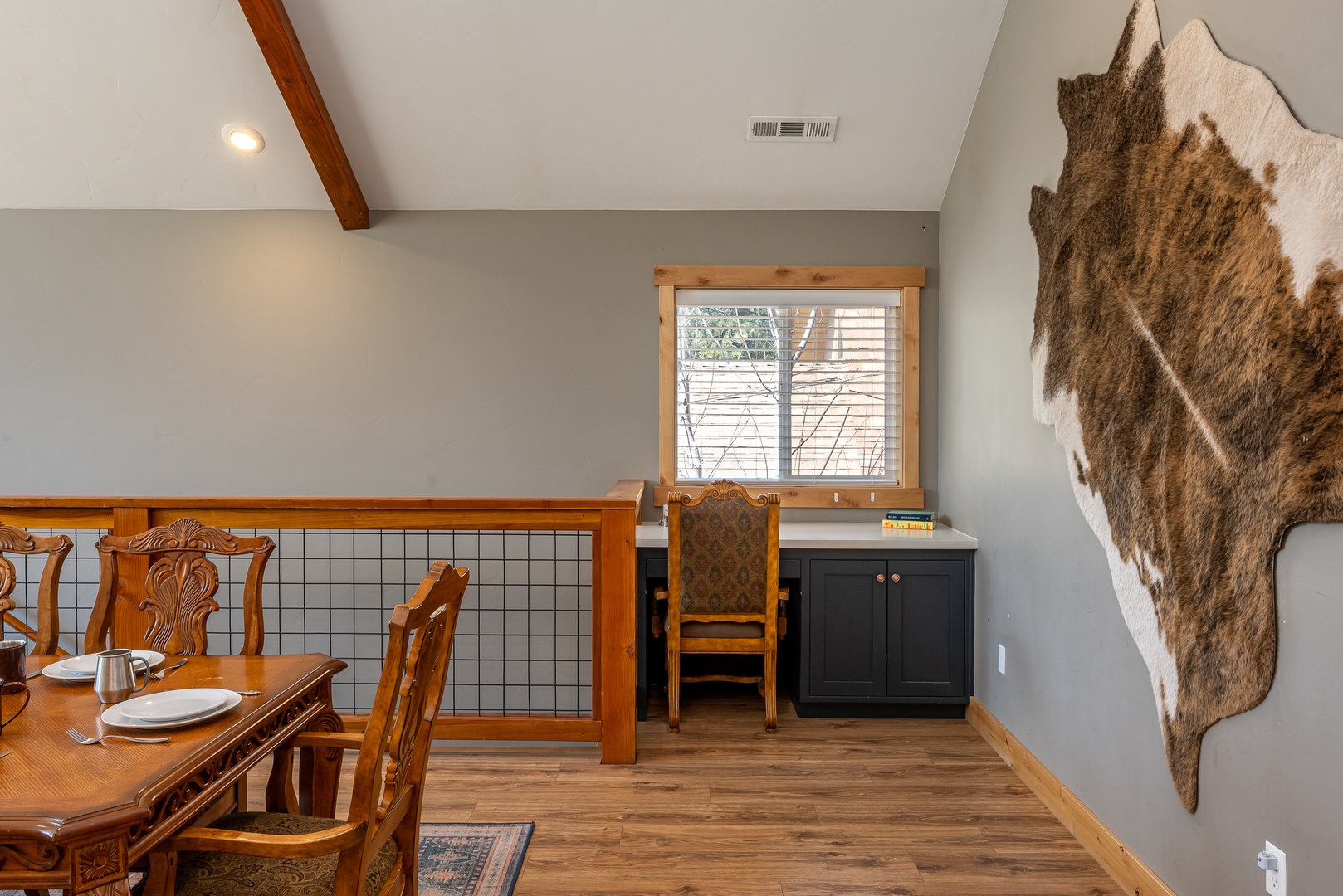 Cozy loft space where rustic charm meets modern comfort—with vaulted ceilings, exposed beams, and a welcoming workspace, this unique nook is all yours to unwind in.