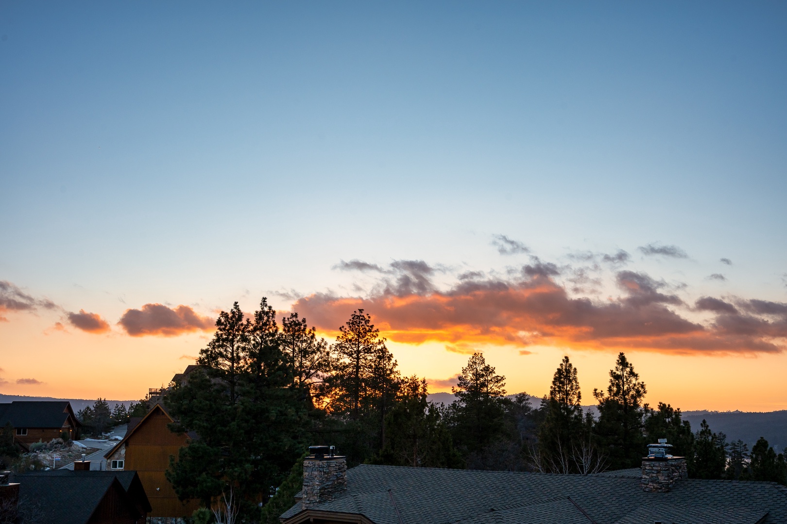 A stunning sunset paints the sky in vibrant oranges and blues above the peaceful residential neighborhood.