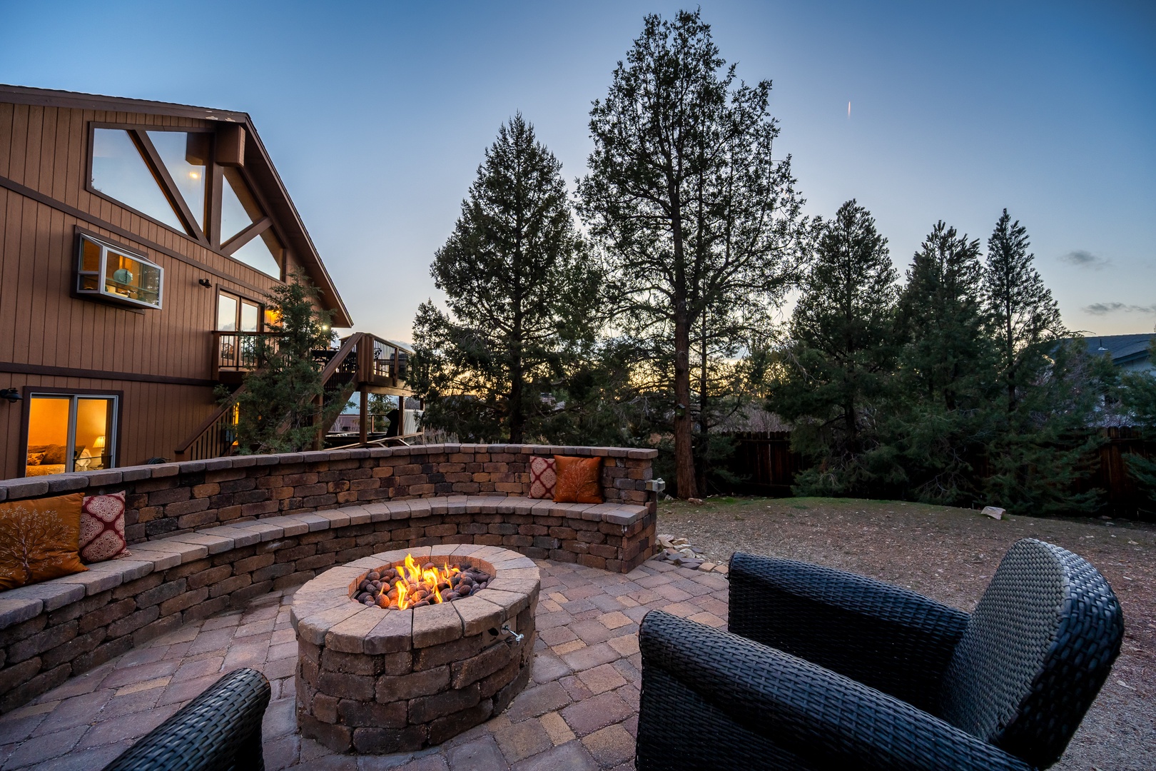 Gather around the fire pit as twilight paints the sky, creating perfect moments for evening conversations in this peaceful outdoor retreat.