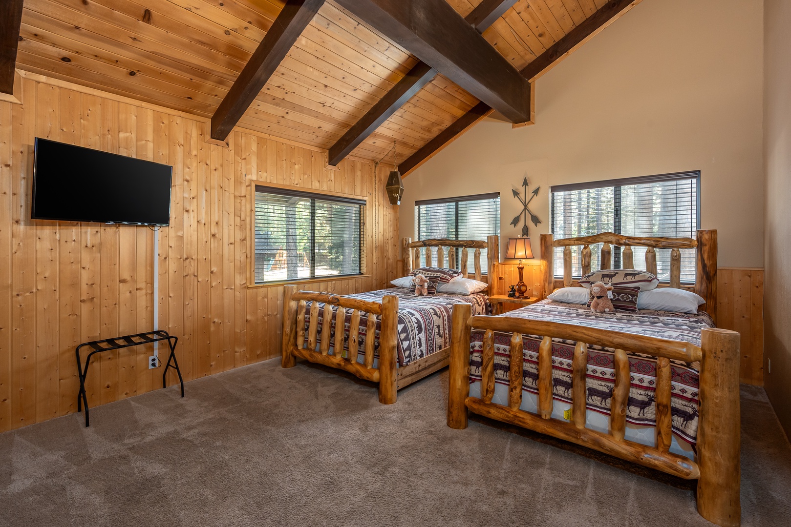 Unwind in your cozy bedroom with rustic log beds, vaulted wood ceilings, and forest views. Plush bedding and warm lighting make this your perfect mountain retreat.