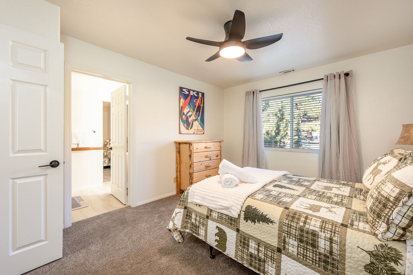Rest easy in this cozy bedroom featuring a ceiling fan to keep you comfortable.