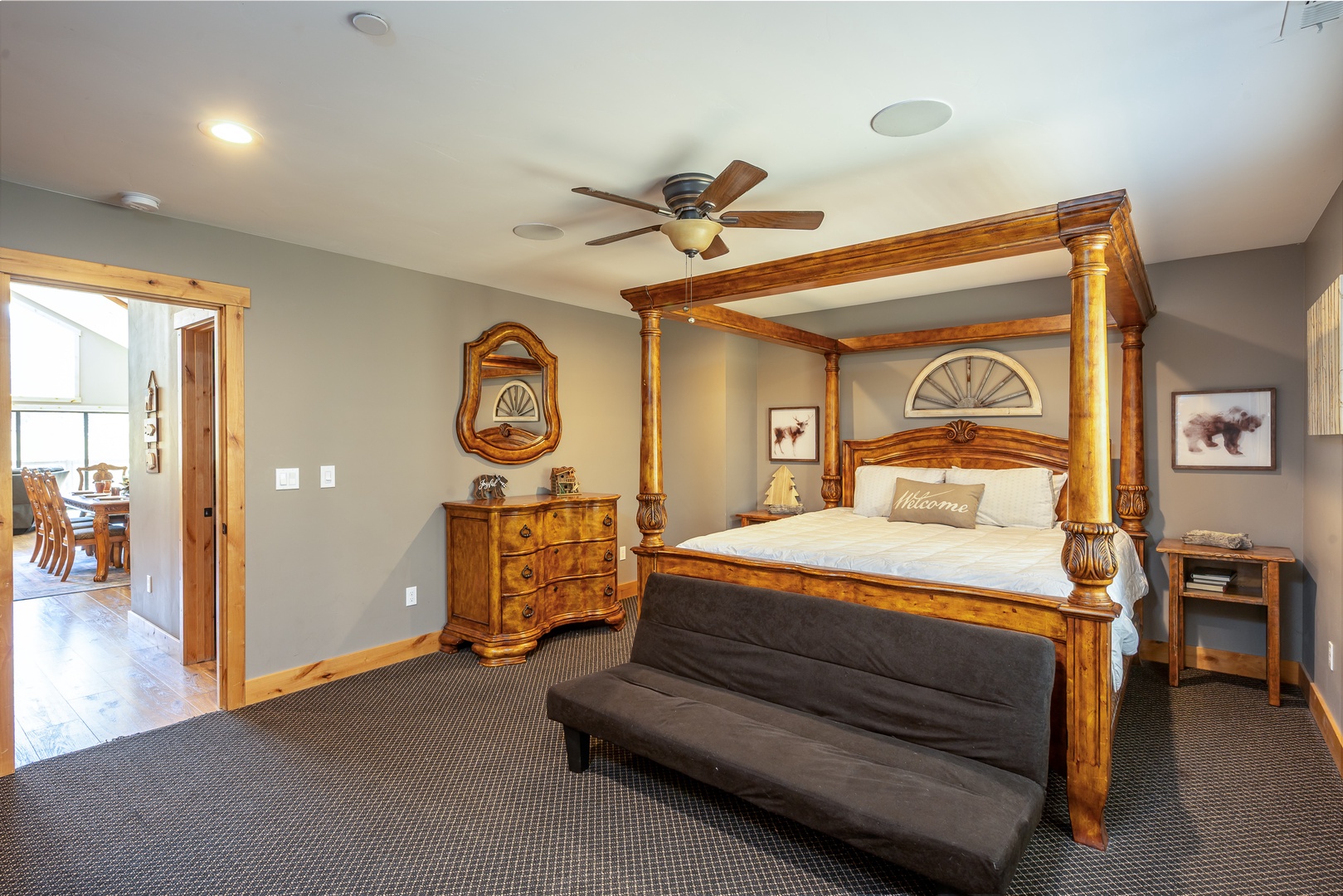 Settle into your spacious suite featuring a stunning four-poster bed, warm wood accents, and a welcoming bench—your perfect retreat after a day of adventure.