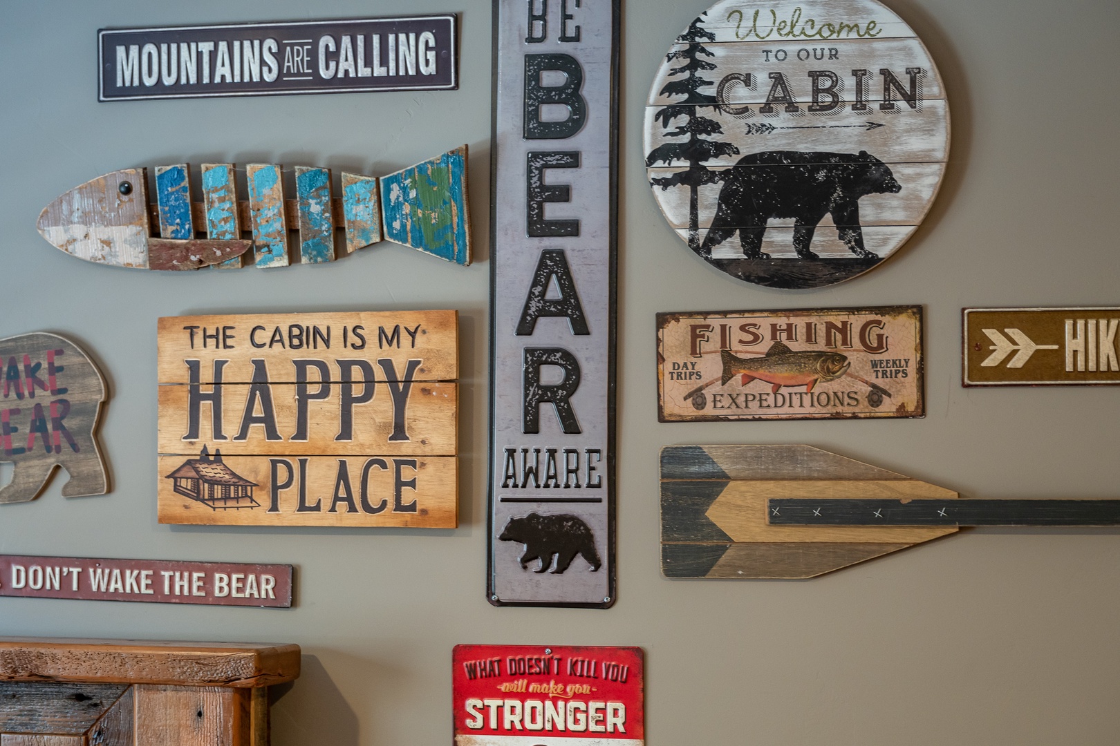 A charming collection of rustic cabin decor brings warmth and character to the wall, welcoming you to your mountain retreat with woodland charm and cozy vibes.