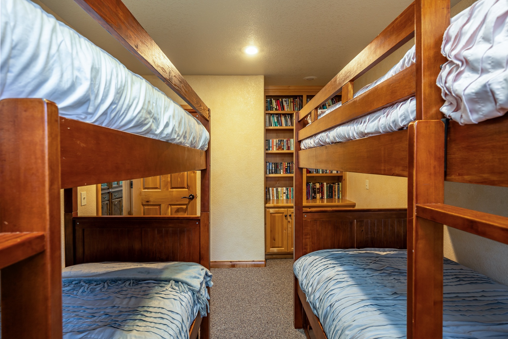 Cozy bunk room with wooden beds and built-in library - perfect for your group's restful nights and quiet reading moments.