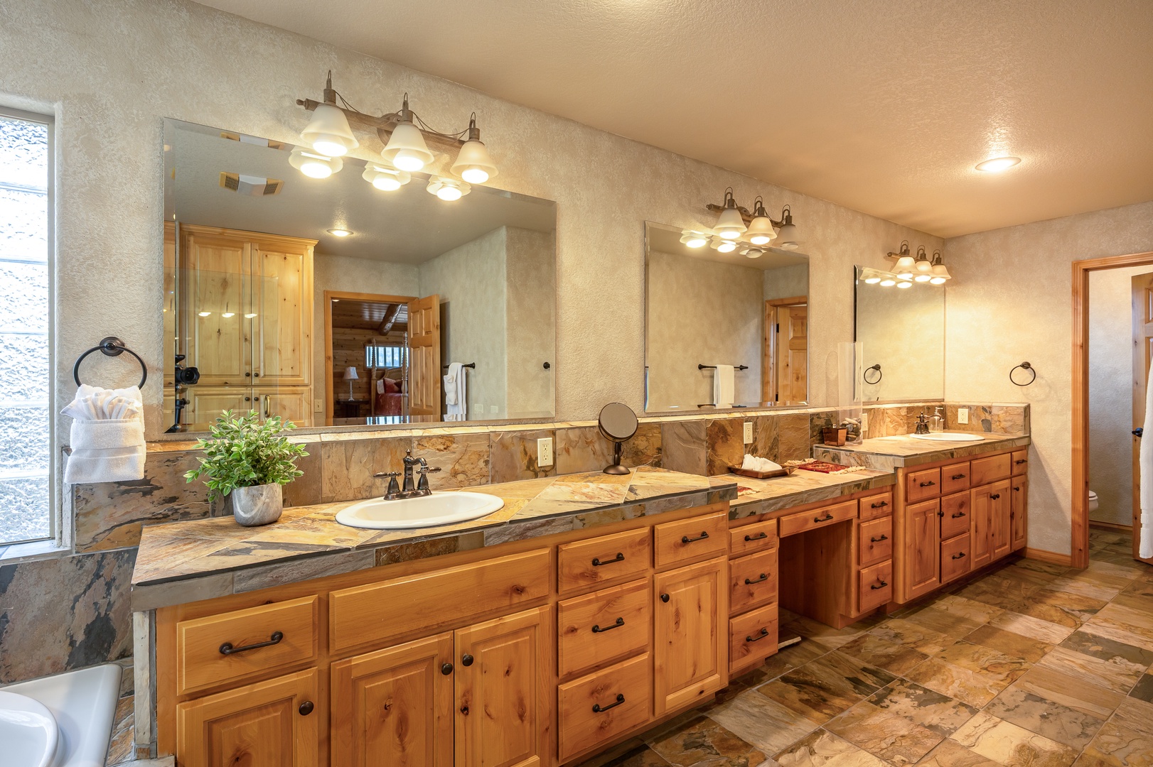 Pamper yourself in this luxurious master bathroom featuring dual vanities, elegant granite countertops, and warm wood cabinetry.