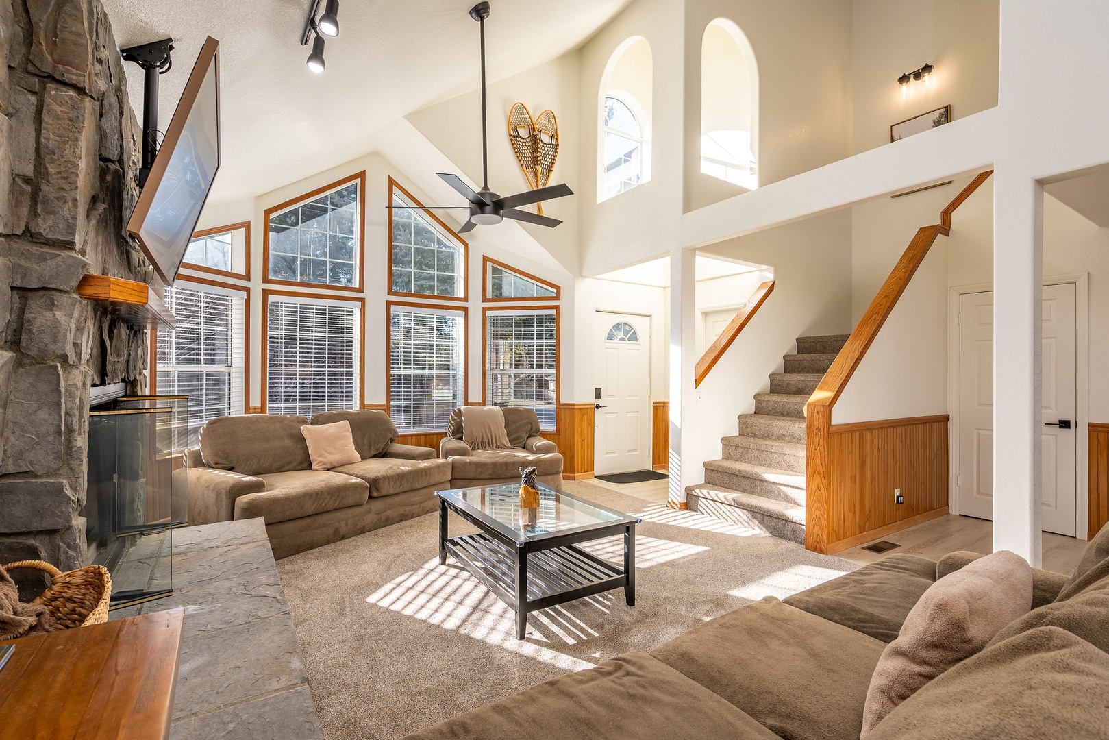 Unwind in your spacious living room with soaring ceilings, cozy fireplace, and floor-to-ceiling windows that flood the space with natural light.