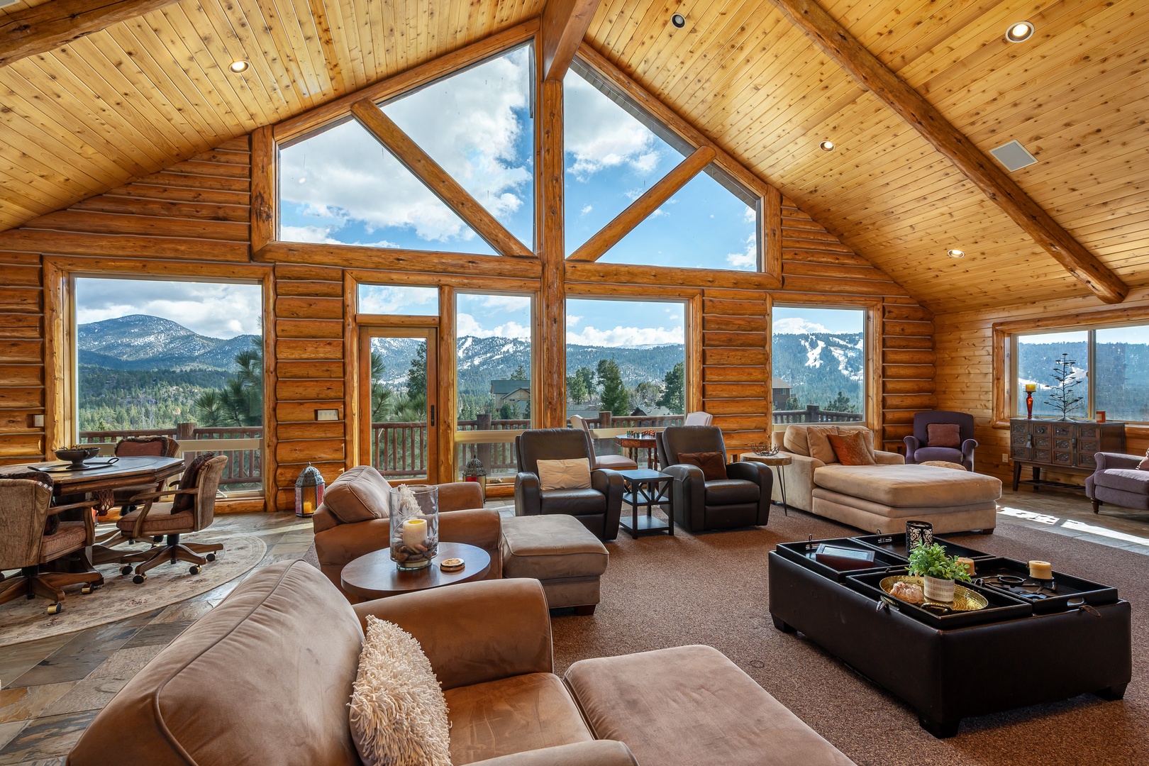 Sink into plush leather seating while soaking up breathtaking mountain vistas through floor-to-ceiling windows in your cozy cabin retreat.