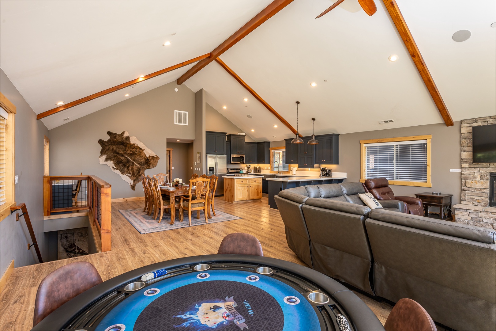 Gather around your elegant open-concept space with soaring ceilings, rustic beams, and a poker table—your perfect retreat for relaxation and fun.