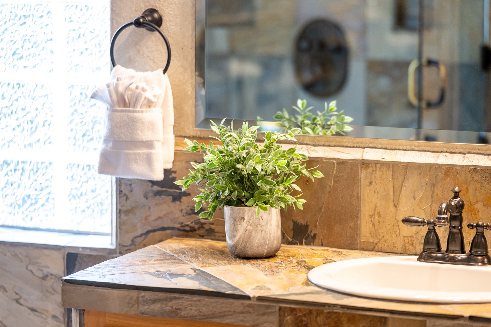 Your elegant bathroom features marble countertops, fresh greenery, and plush towels - creating a spa-like retreat for your daily refresh.