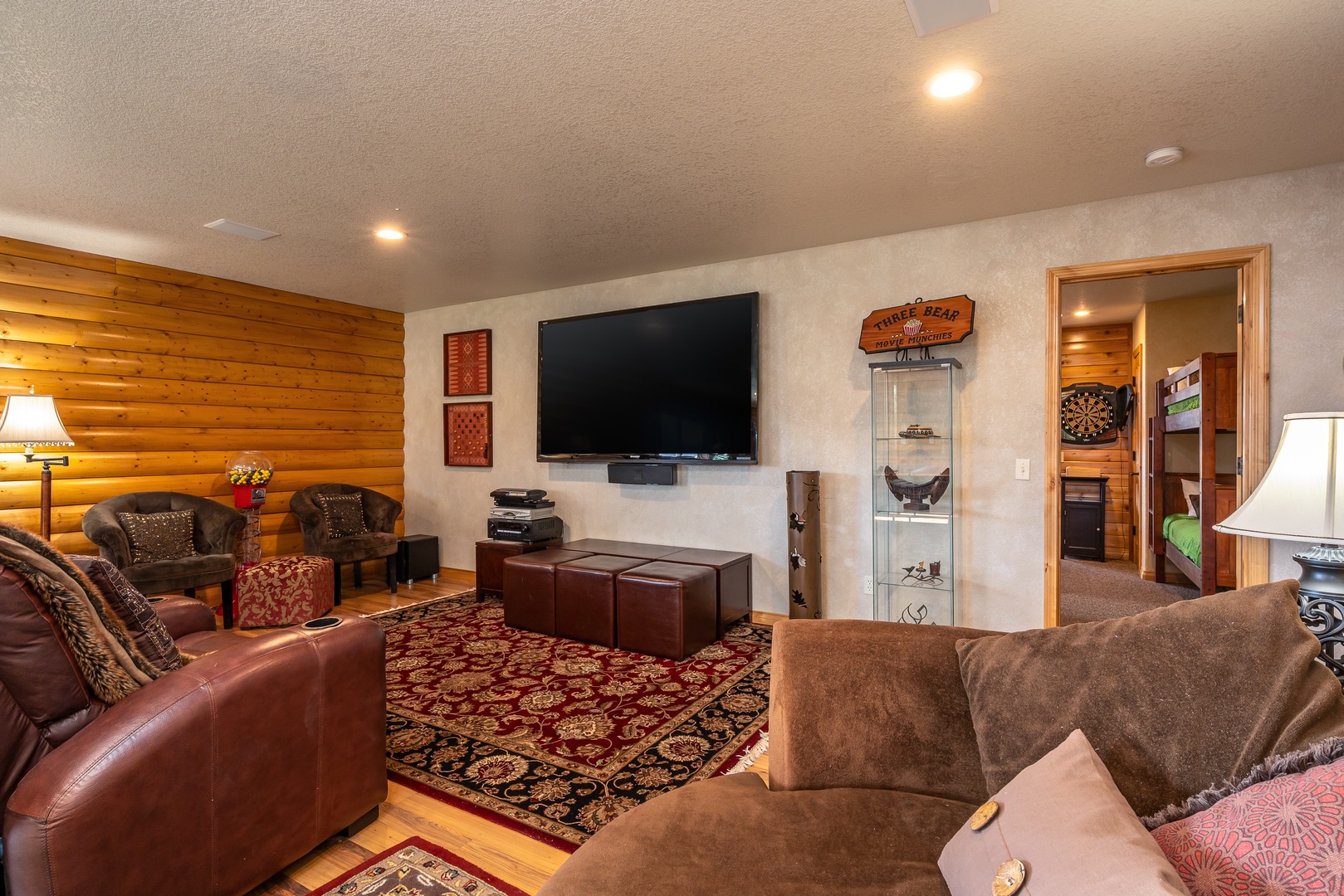 Cozy up in your spacious living room with plush leather seating, warm wood accents, and entertainment center for perfect family movie nights.