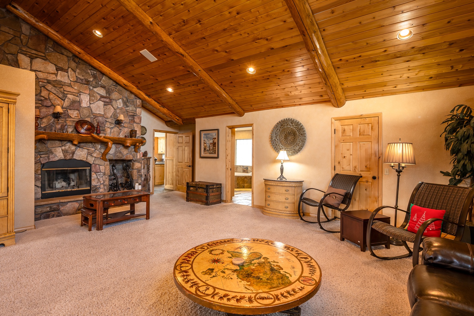 Unwind in your spacious living room featuring a stunning stone fireplace, vaulted wood ceilings, and comfortable seating perfect for cozy evenings.