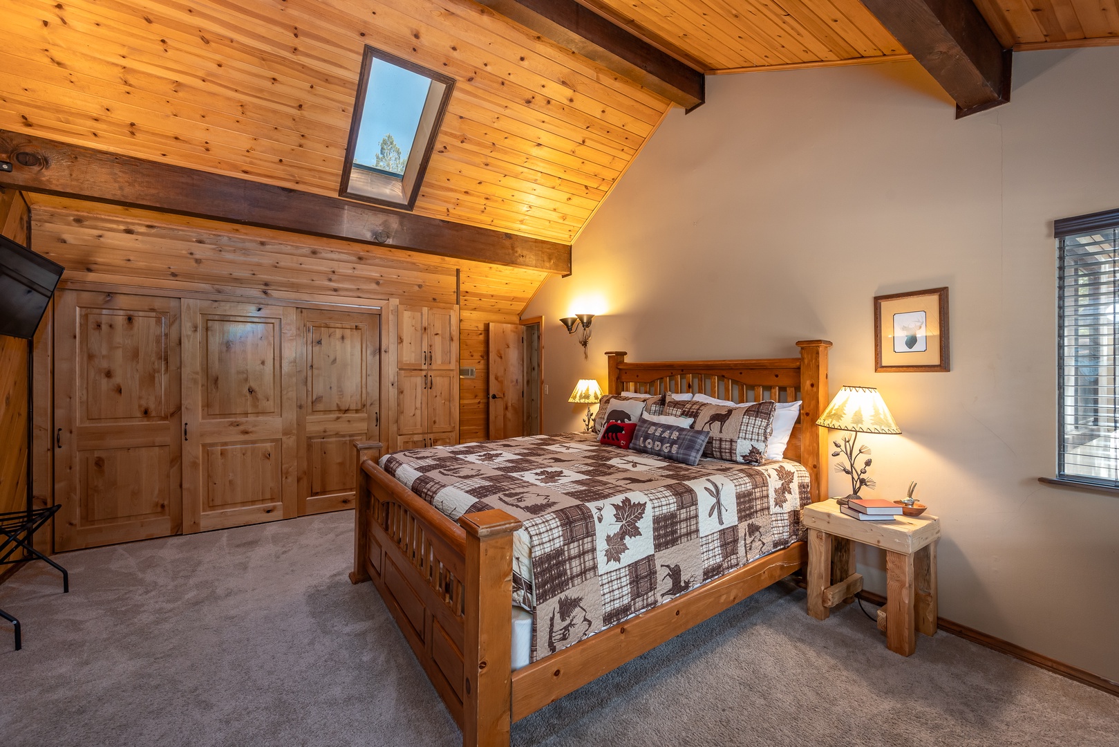 Sink into the warmth of this handcrafted log bed, where rustic beams and a soaring skylight frame your peaceful mountain retreat.