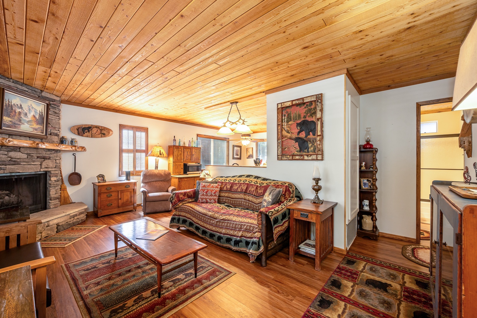 Cozy up in your rustic retreat with warm wood ceilings, stone fireplace, and charming cabin decor that welcomes you home.