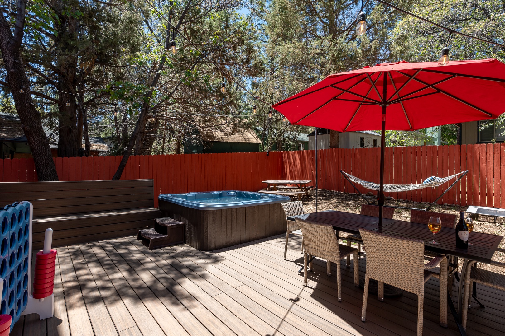 Your private outdoor oasis awaits with a spacious deck, bubbling hot tub, hammock swaying under the trees, and dining for sunny afternoons or starlit evenings.
