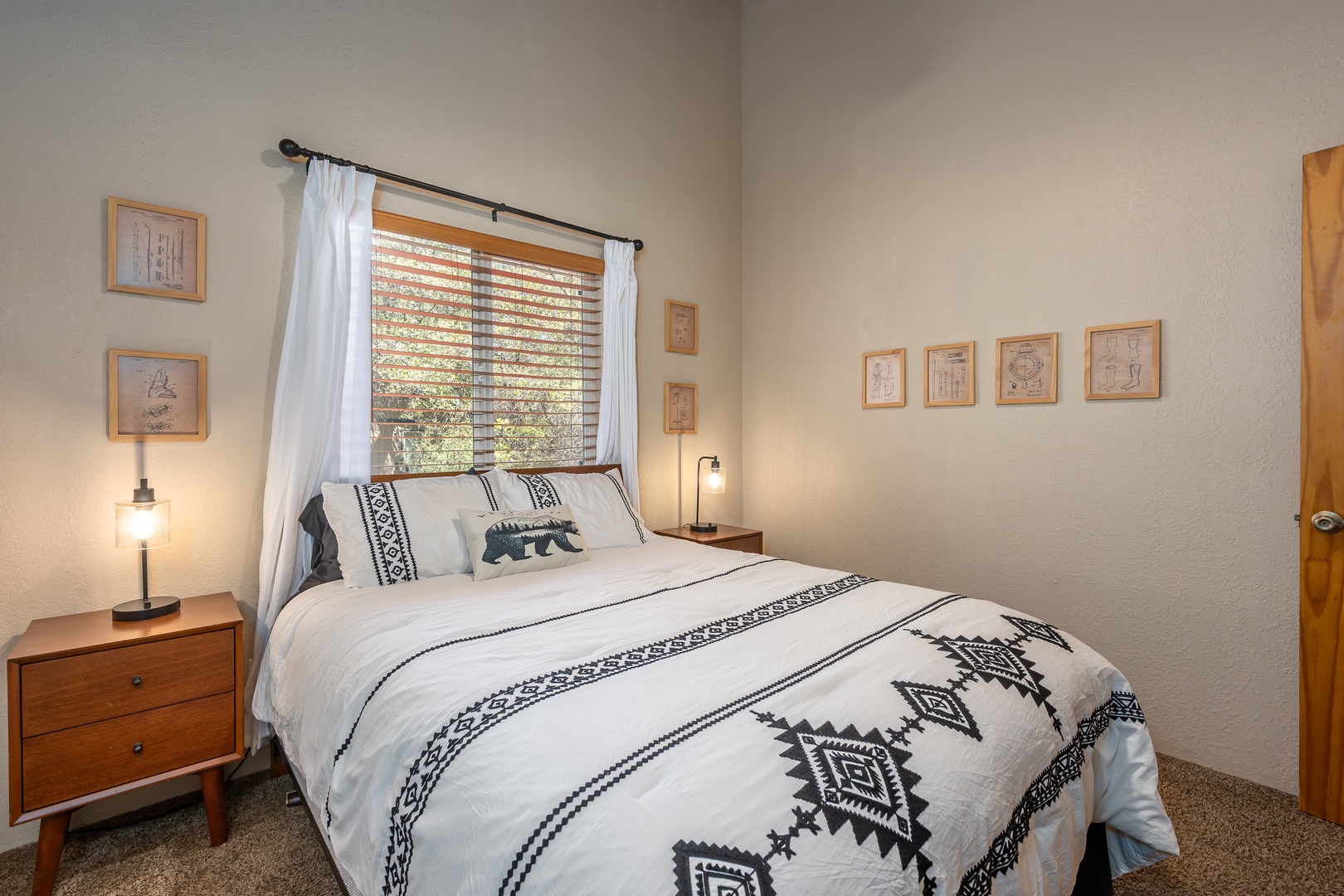 Cozy bedroom with plush bedding and soft natural light filtering through bamboo blinds. Unwind in your peaceful retreat after a day of adventure.
