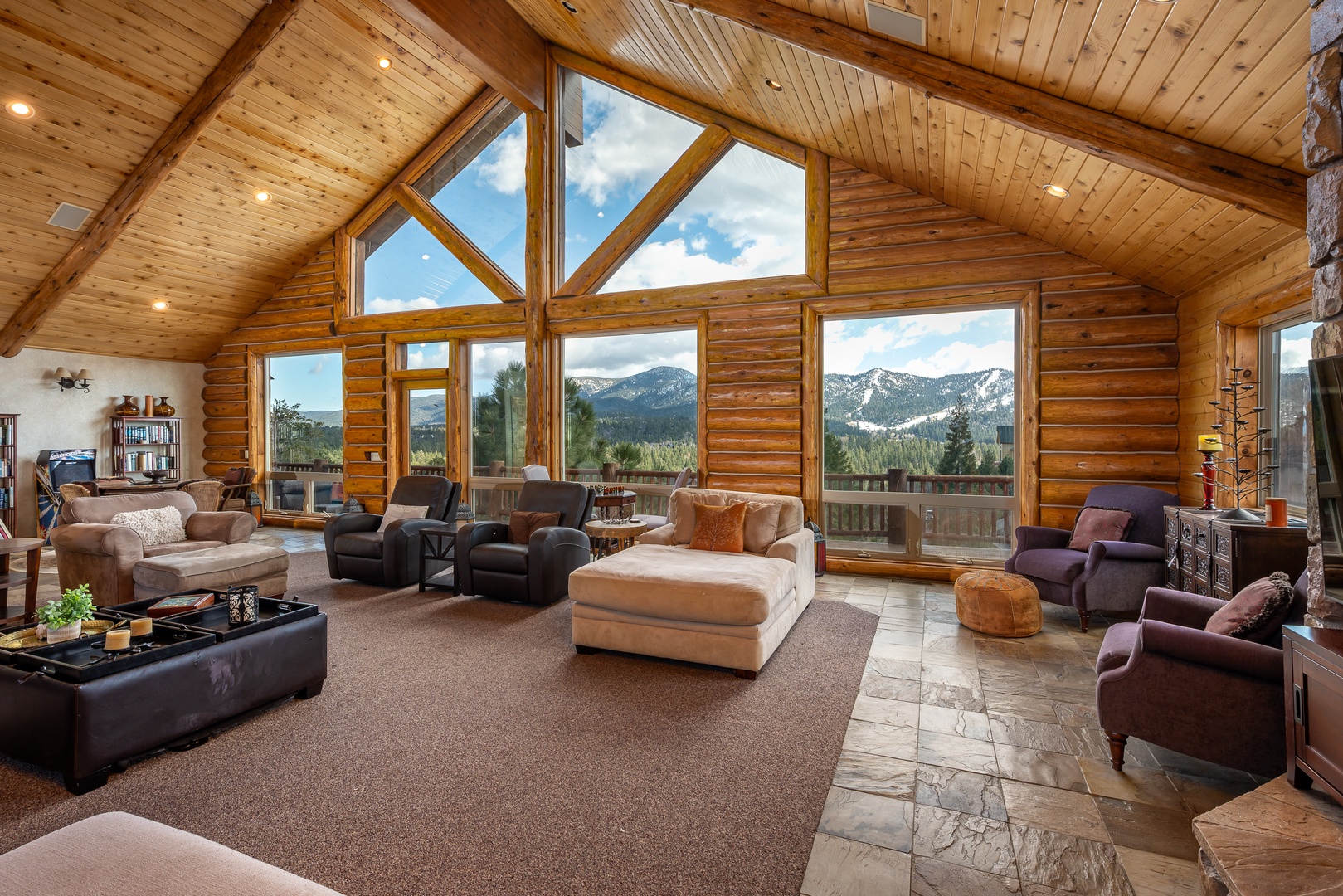 Relax in your spacious living room with soaring ceilings and panoramic mountain views through floor-to-ceiling windows.