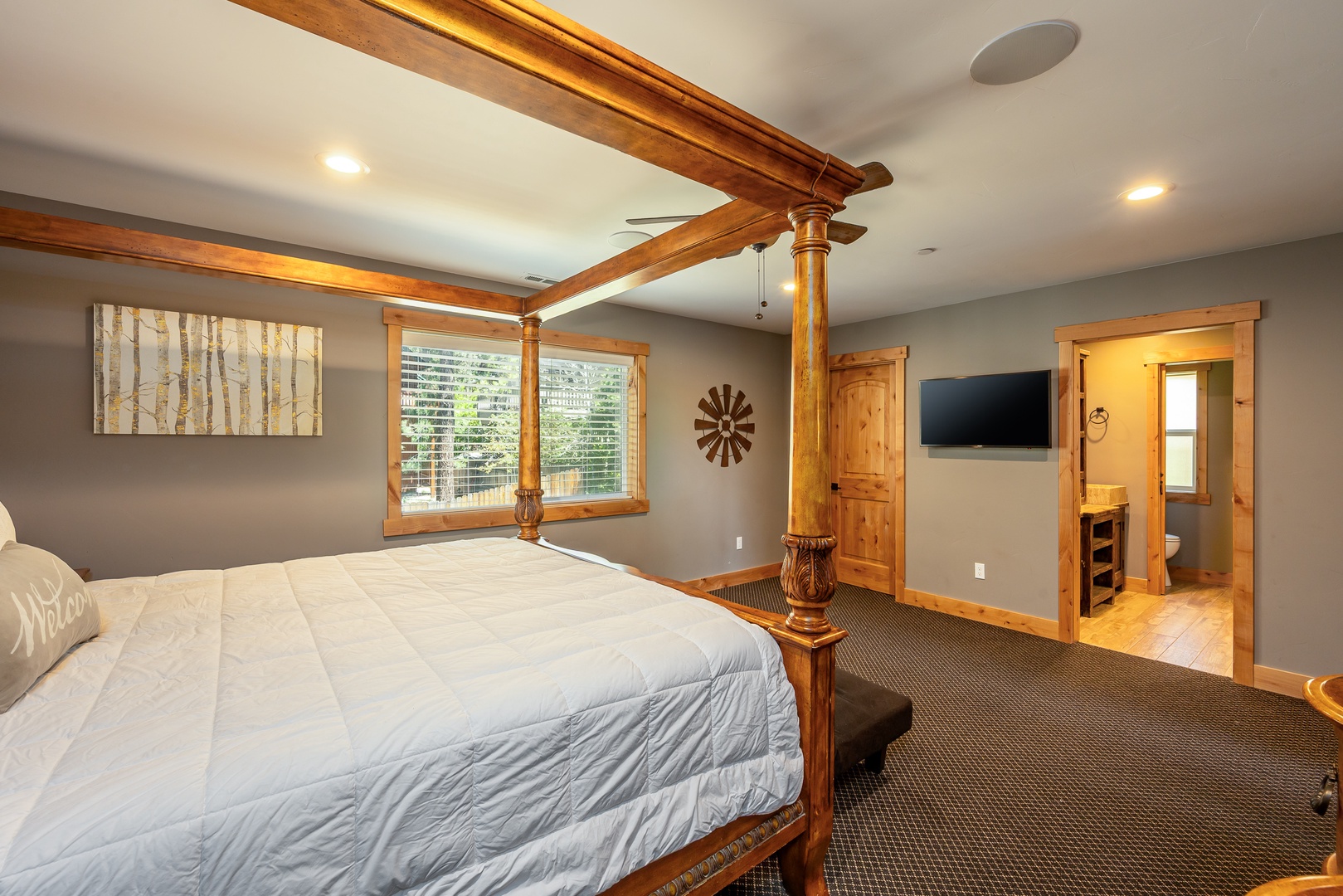 Retreat to your private sanctuary where rustic wood beams meet modern comfort. Sink into a plush bed beneath soaring ceilings while your ensuite awaits, promising restful nights in mountain style.