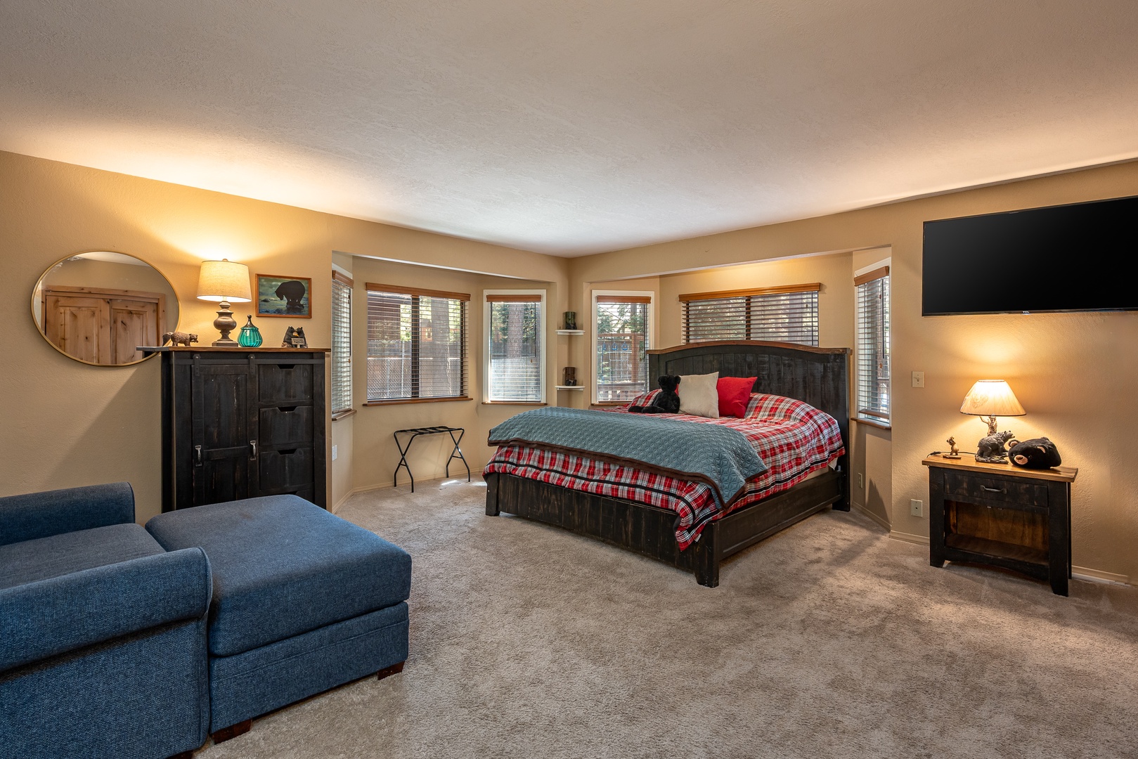 Spread out in your spacious master suite with cozy seating, a plush bed dressed in rustic linens, and peaceful forest views framing every window.