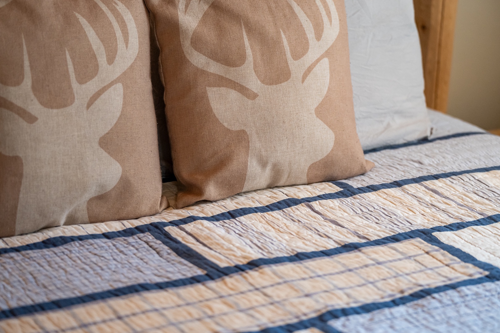 Sink into comfort with charming deer-patterned pillows and a cozy quilted bedspread that promises restful nights in your home away from home.