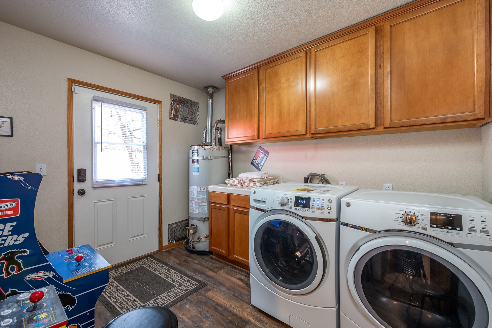 Your laundry room features a full-size washer and dryer, overhead storage cabinets, and a convenient water heater for all your stay needs.