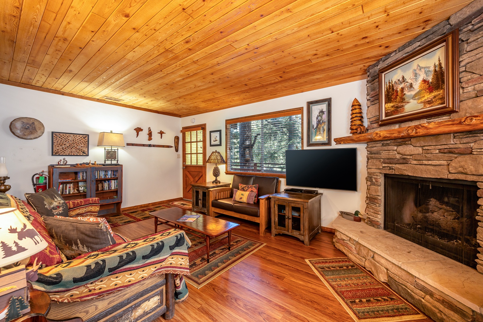 Cozy up in this rustic living room with crackling fireplace, Native American decor, and warm wood beams creating your perfect mountain retreat.