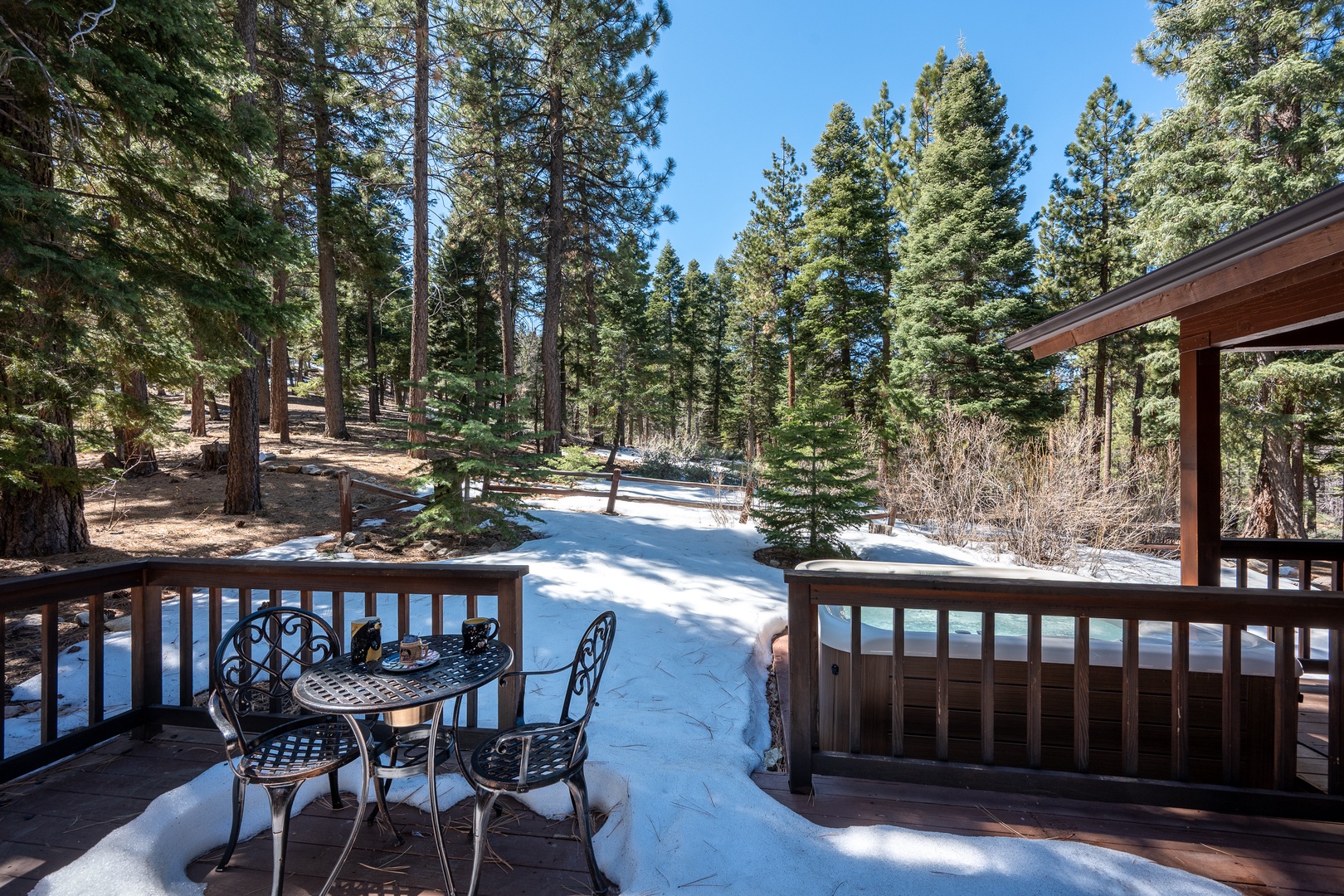 A peaceful mountain retreat surrounded by towering pines and gentle winter snow, offering seclusion in nature's quiet beauty.