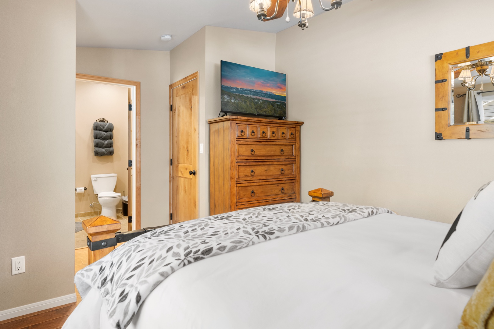 Step into your serene bedroom featuring a plush bed, charming wooden furnishings, and your own private bathroom. Unwind with your favorite shows on the TV and store your belongings in the wardrobe.