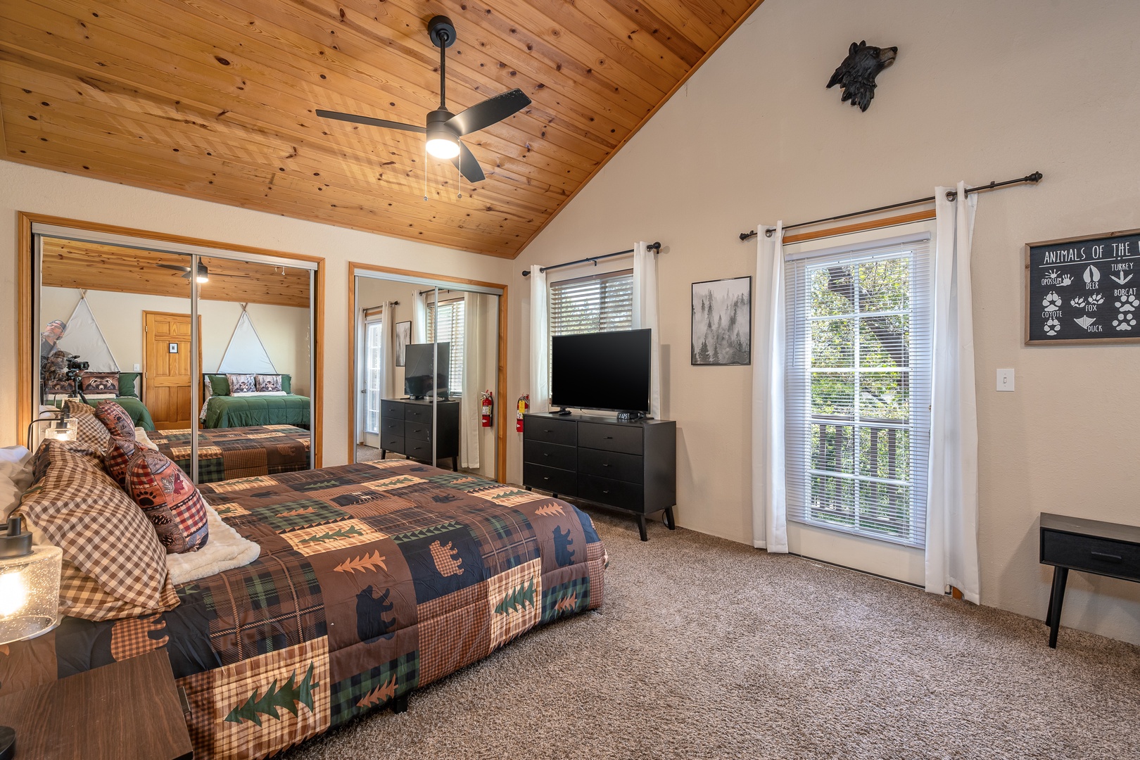 Sink into the plush quilted bed beneath soaring wood-paneled ceilings, where rustic charm meets modern comfort with thoughtful touches throughout your inviting retreat.
