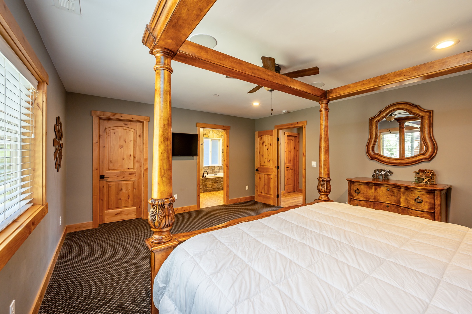 Unwind in your spacious bedroom, where rich wooden accents and a plush bed create a warm, inviting retreat. Natural light filters through, highlighting the craftsmanship and comfort waiting for you.