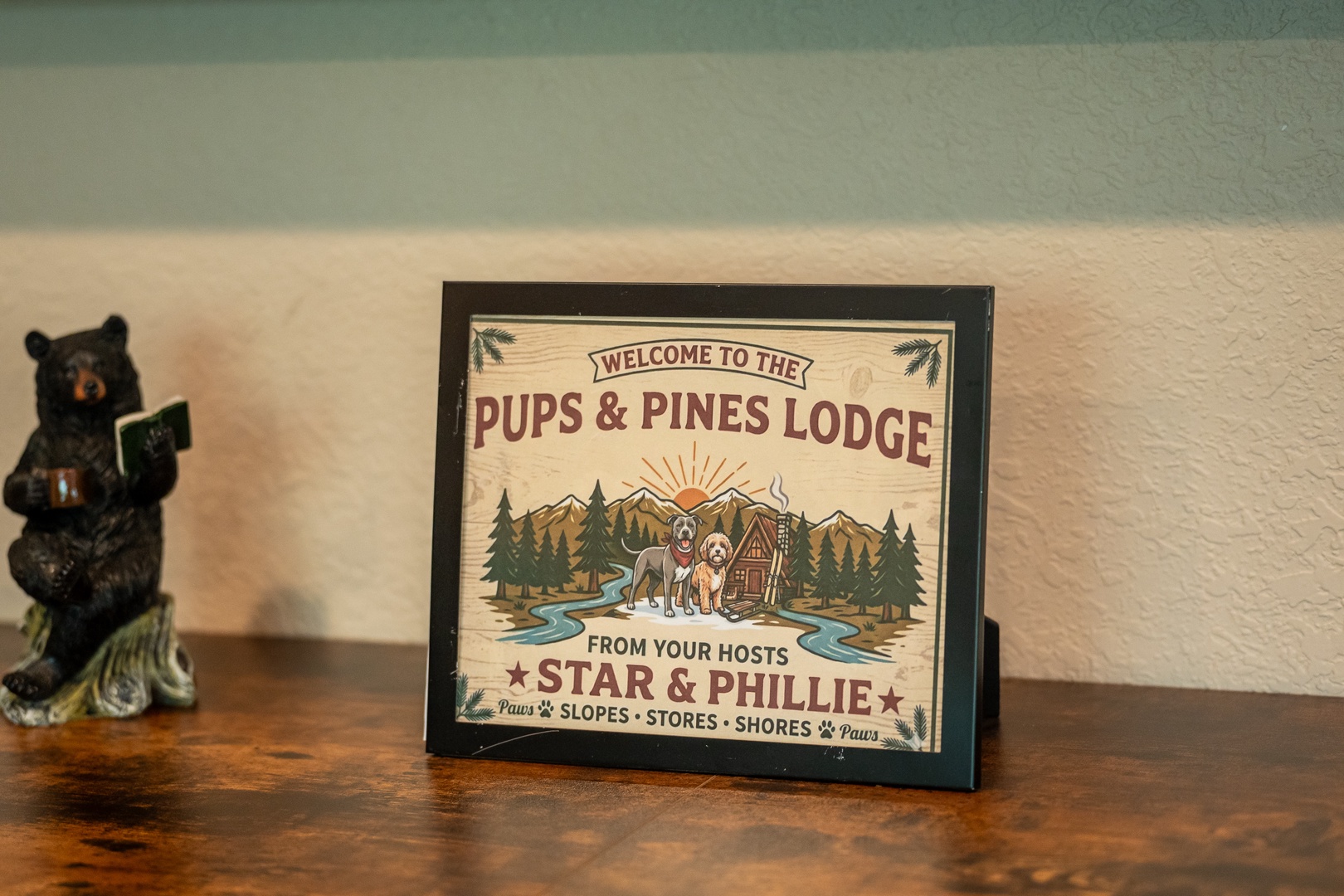 Pups & Pines Lodge welcomes guests with rustic charm, featuring personalized signage from hosts Star and Phillie, complemented by a charming bear figurine.