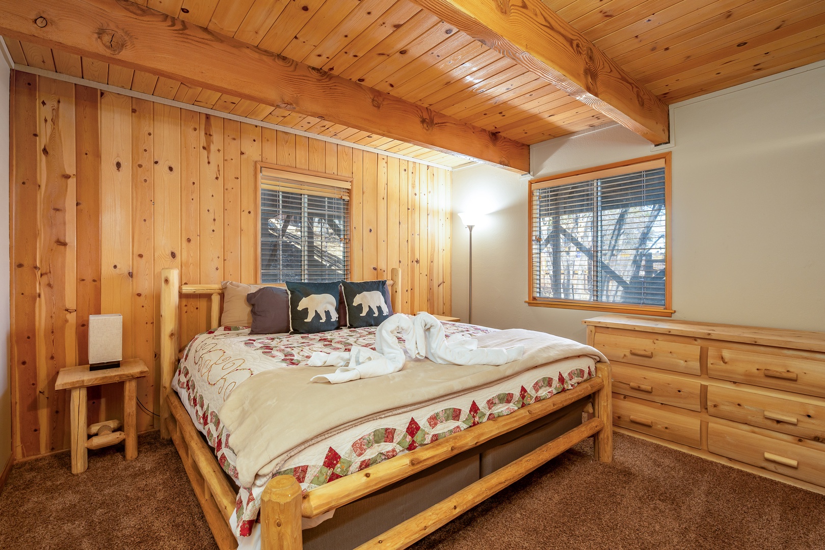 Your cozy mountain bedroom wraps you in warm pine walls and rustic charm, complete with comfortable bedding and peaceful forest views.